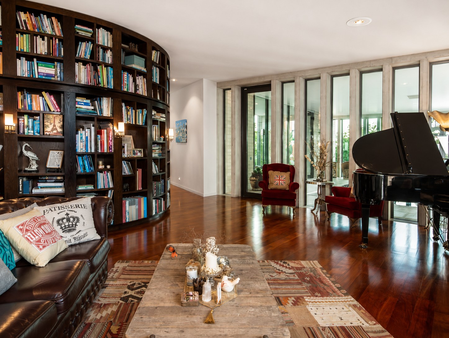 Curved library wall and grand piano in a high-ceilinged room