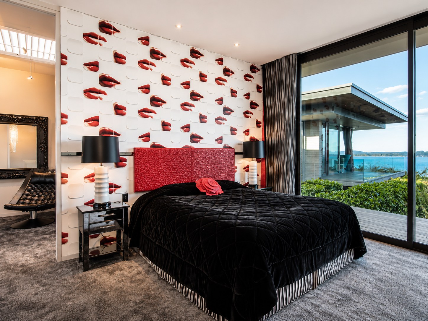 Bold bedroom with red lips wallpaper and harbour views